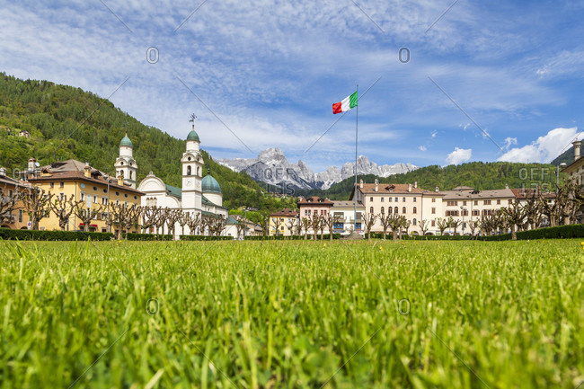 The center of Agordo with the church with two bell towers and the large green lawn called 'broi', agordino, belluno, veneto, italy