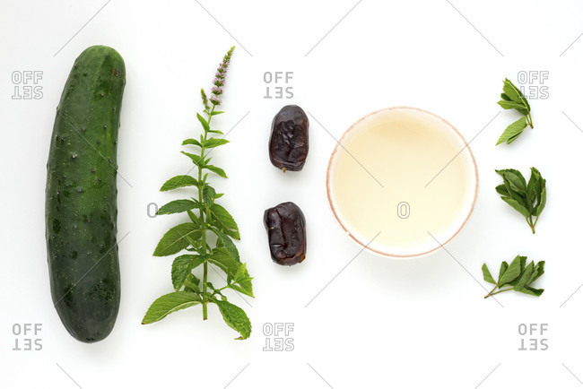 Ingredients for a wild herb smoothie as a laying picture on a pure white background.