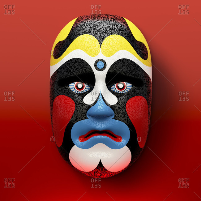 Asian theater mask with colored ornaments against a red background
