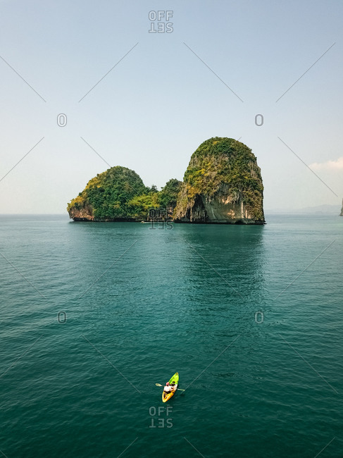 Aerial view of kayaks and canoes exploring the giant limestone cliffs and islands in the turquoise blue sea, a tropical paradise, Phra Nang, Krabi, Phuket, Thailand.