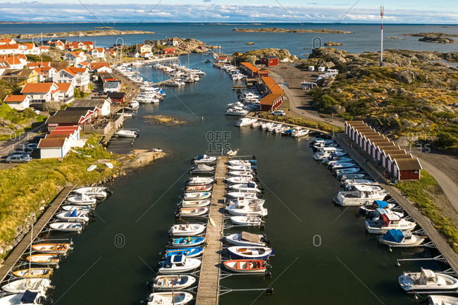 Aerial view of harbor area with anchored boats and red boat houses, Gothenburg Archipelago, Sweden.