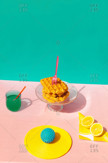 Studio shot of waffle- juice- lime and rubber ball kept on table