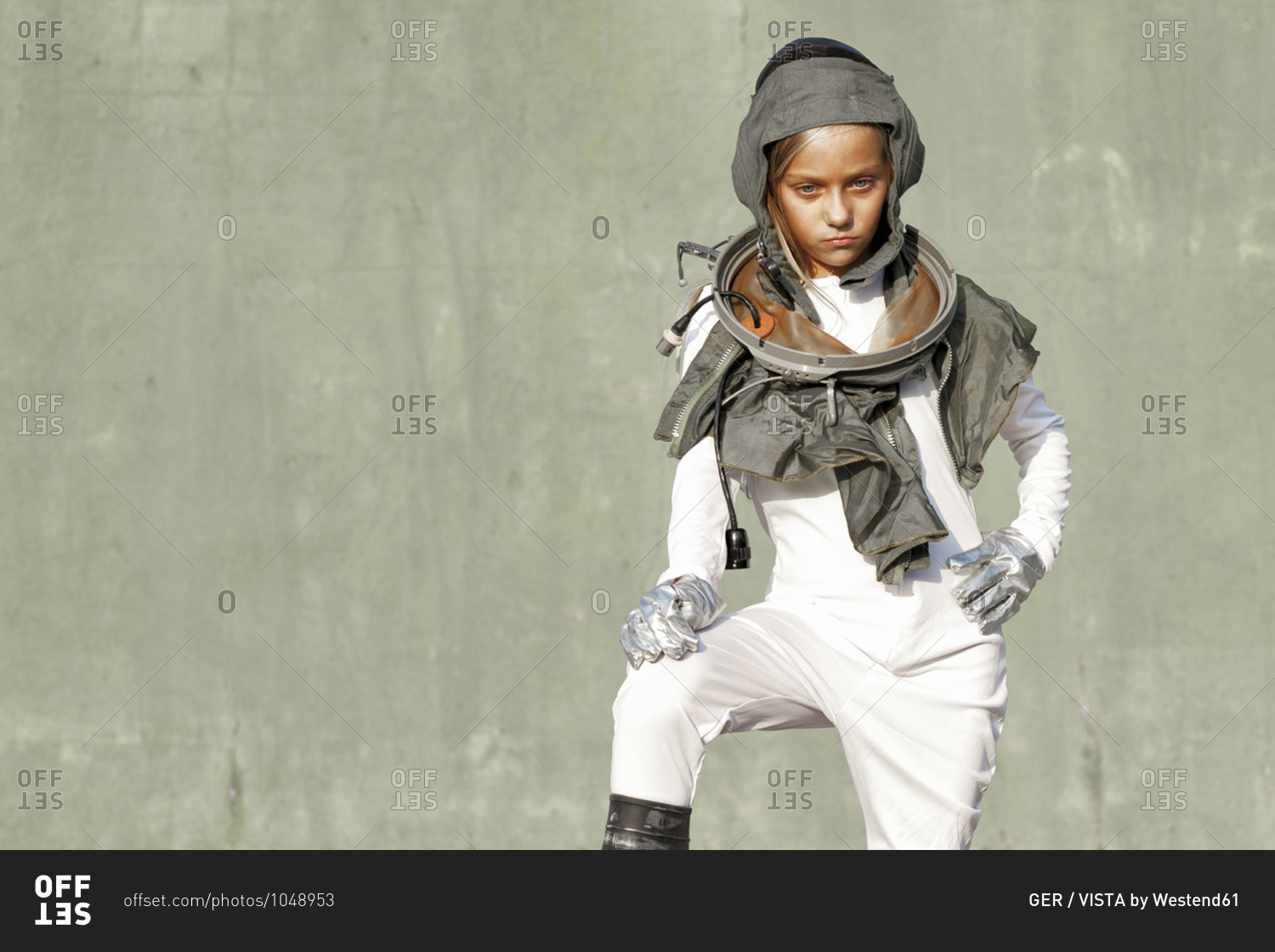 Girl with hand on hip wearing space suit standing against wall during sunny day