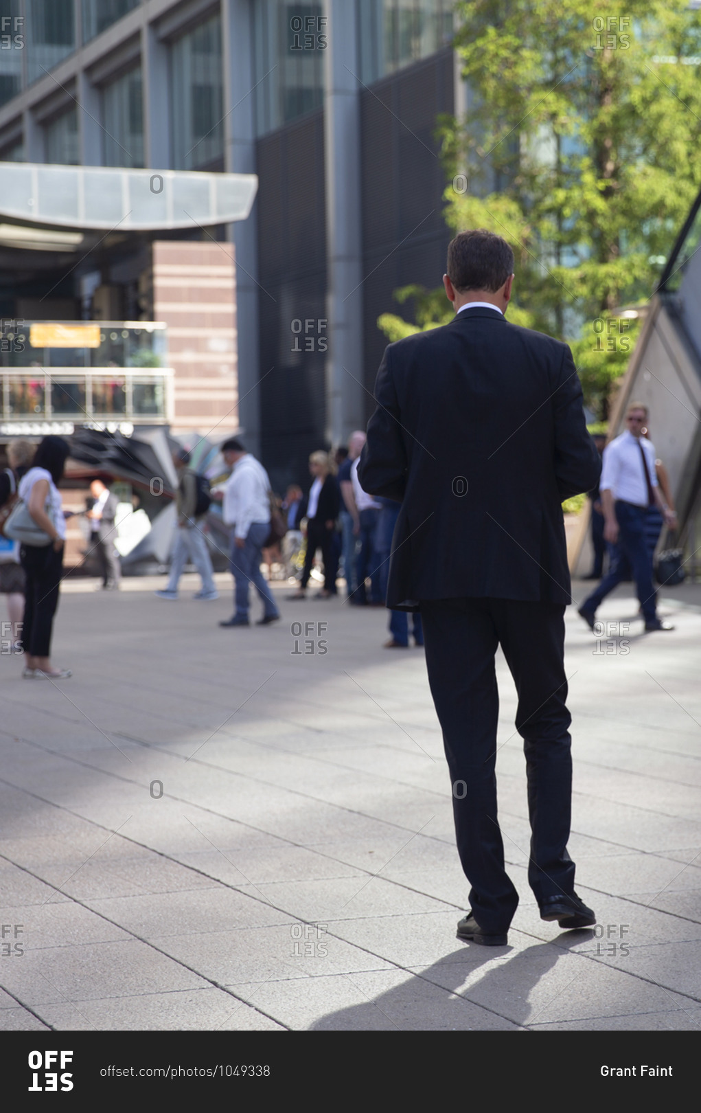 Rear view of an executive businessman walking at the Canary Wharf business district