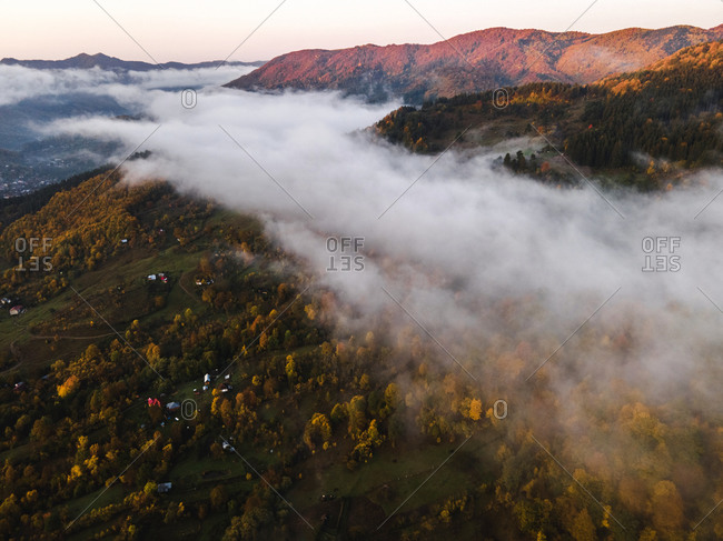 Fog above homes in the mountains at sunrise