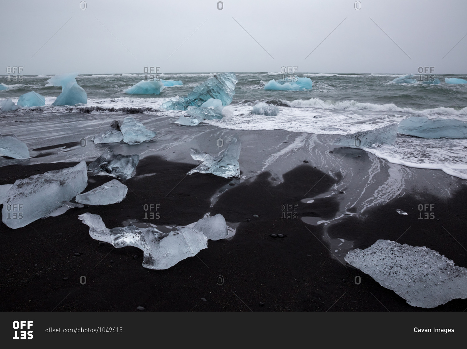 Black sand strewn with iceberg chunks on diamond beach, iceland