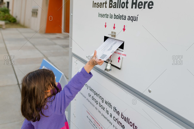 Washington, dc, united states - october 23, 2020: little girl placing ballot in a drop box for absentee voting