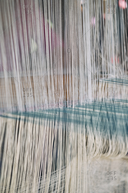 Colorful silks being made on a traditional loom for weaving scarves and blankets