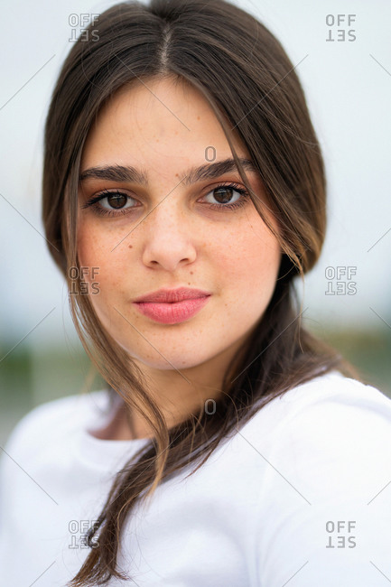 Close up portrait of a pretty young brunette woman looking at camera