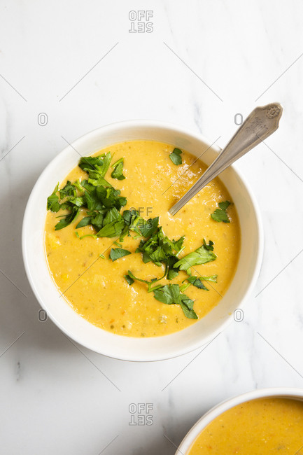 Overhead angle of vegetarian creamy corn chowder served in a white bowl