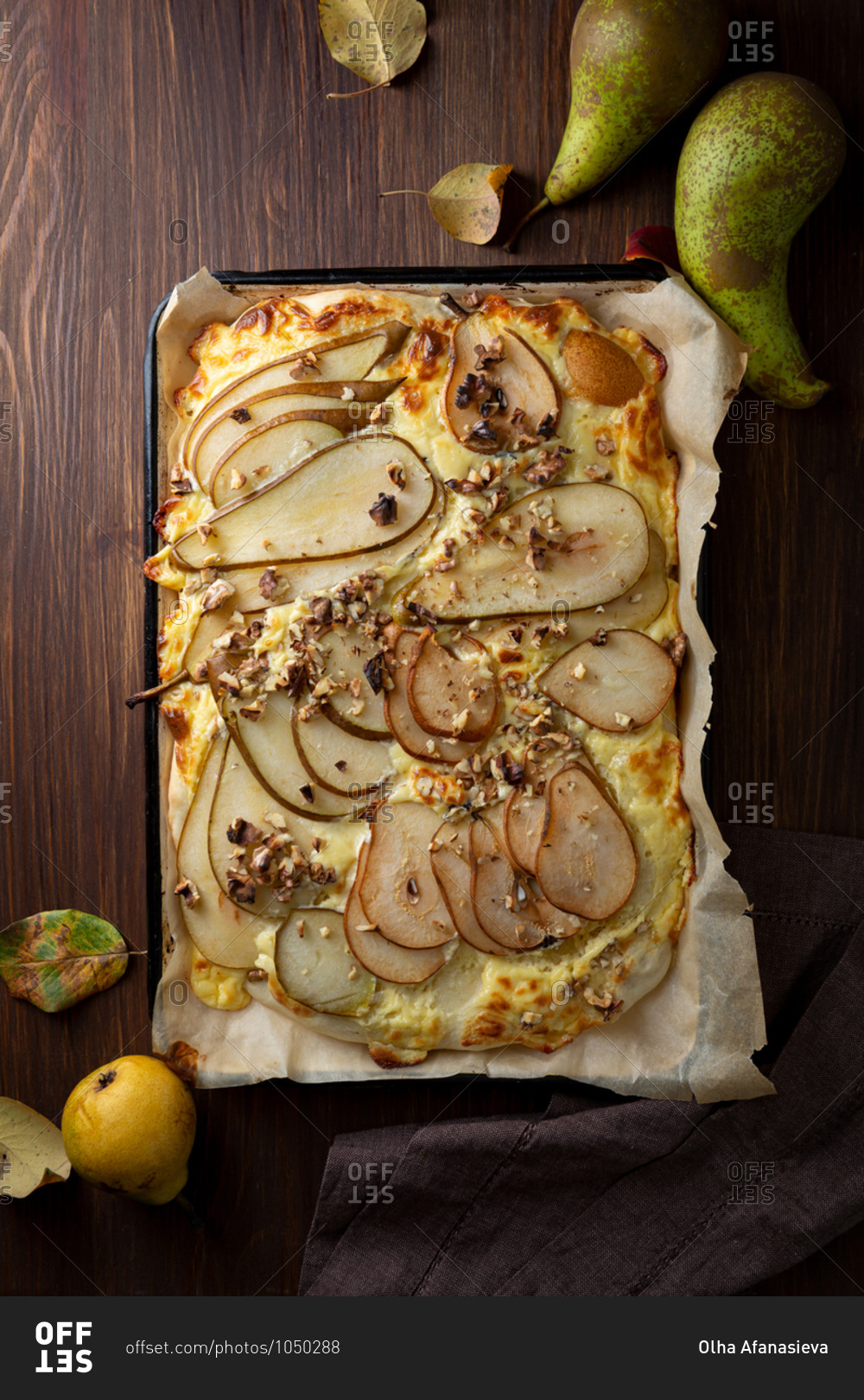 Freshly baked pear pizza on a rustic wooden table