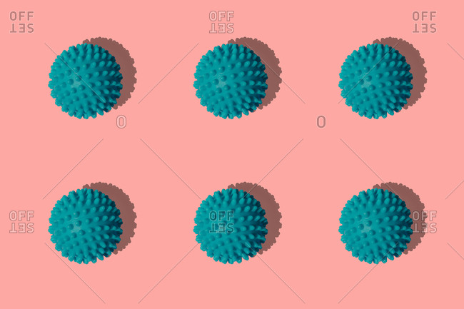 Teal sports balls arranged on colored background