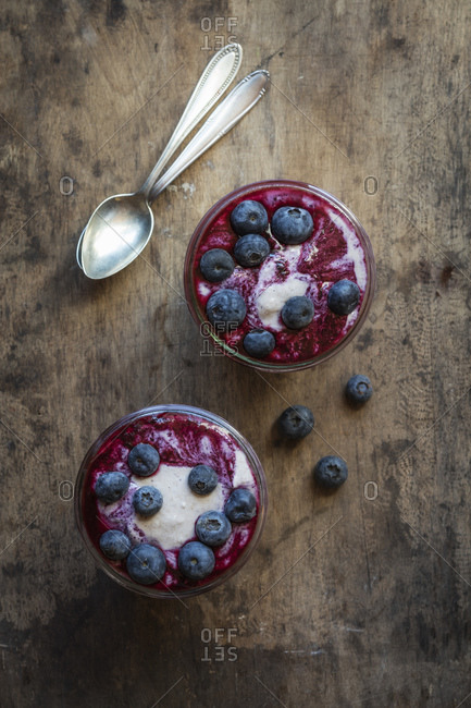 Garnished blueberry buckwheat porridge cups kept by spoon on table