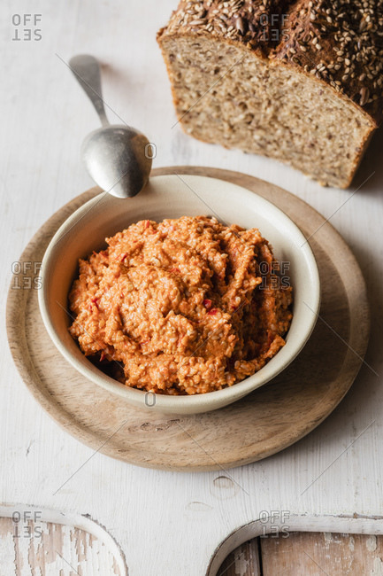 Paprika and sesame spread bowl kept with loaf of bread serving dish