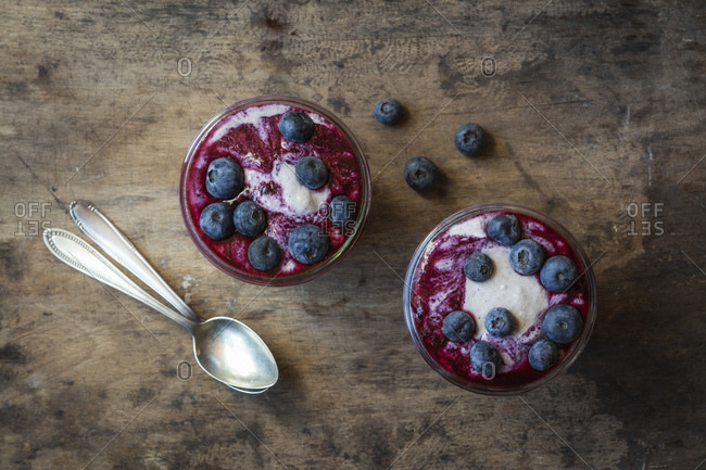 Cups of blueberry buckwheat porridge with blueberry topping on table