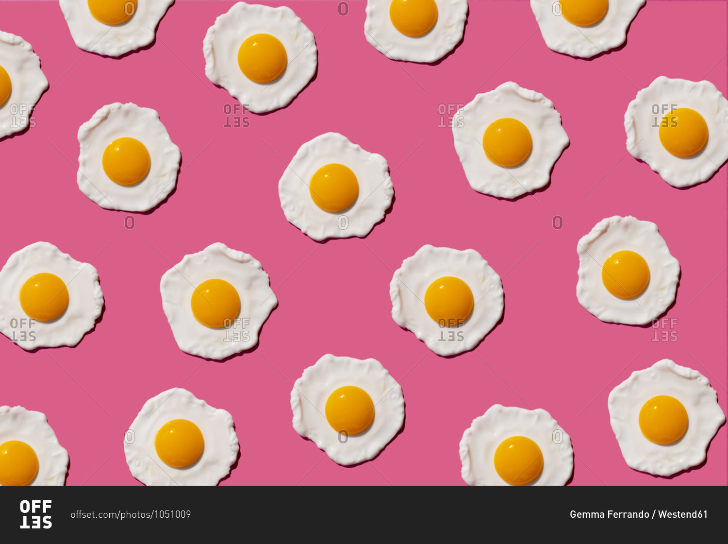 Pattern of fried eggs against pink background