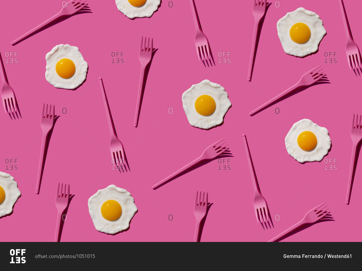 Pattern of pink plastic forks and fried eggs against pink background