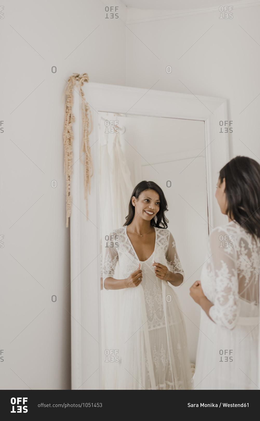 Reflection of young bride looking in mirror at home