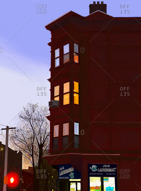 Brooklyn, New York City, New York - September 22, 2020: View of a brick apartment building in Brooklyn with a laundromat at twilight