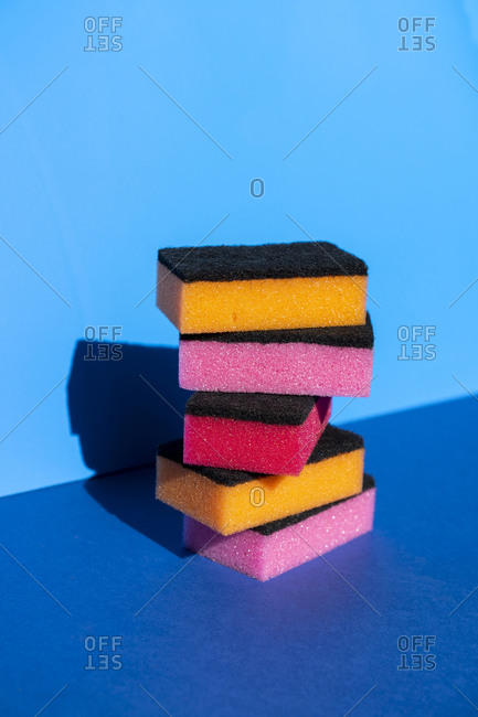Stack of colorful cleaning sponge on blue background
