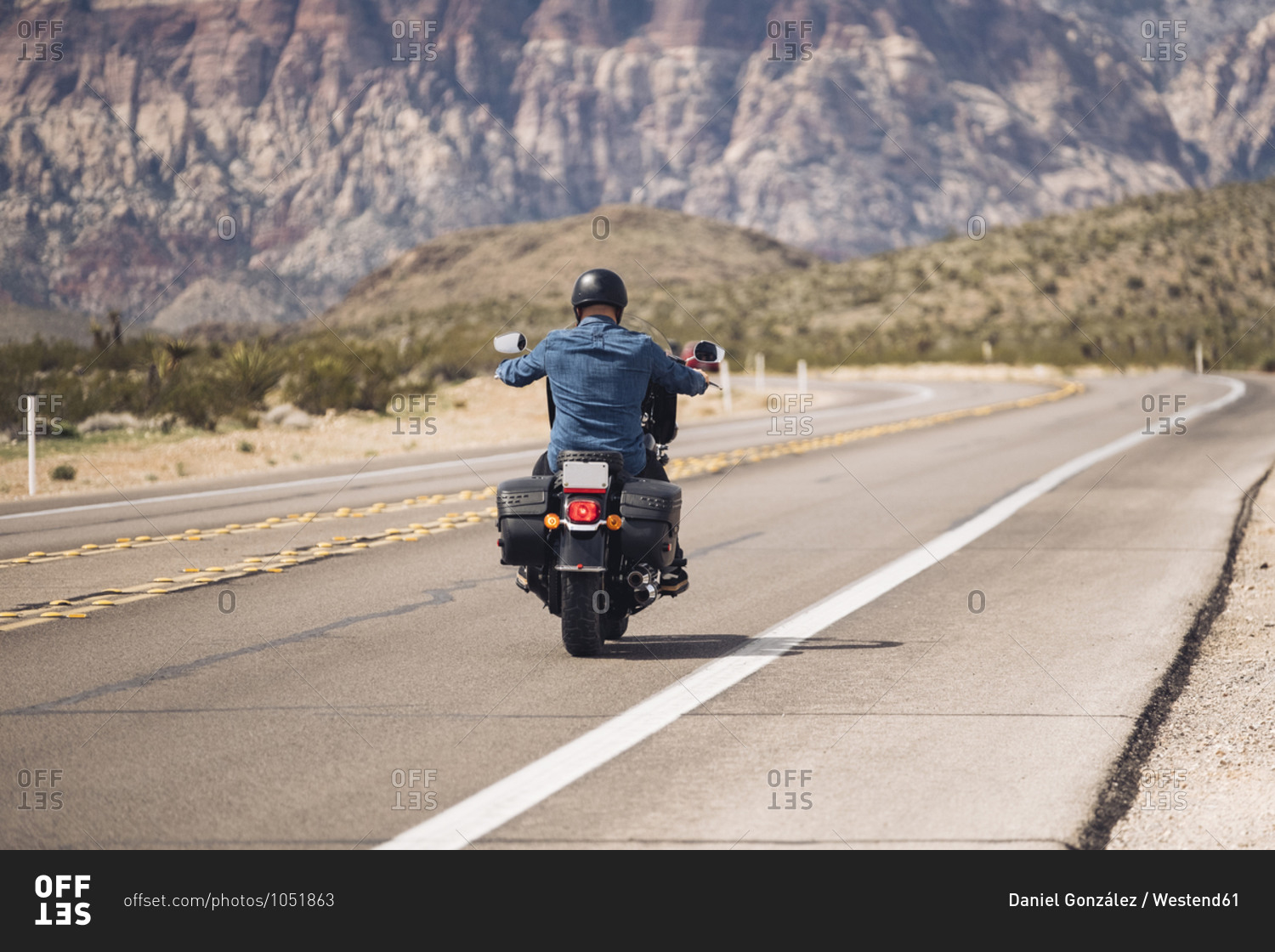 Man riding motorcycle on desert road- Nevada- USA