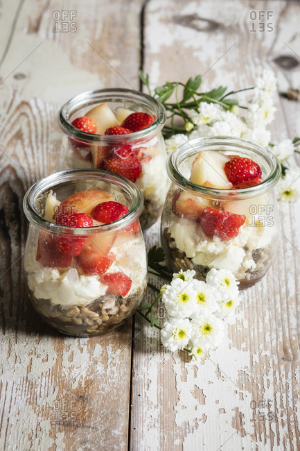 Small jars of sweet layered mascarpone cheese dessert with fruits