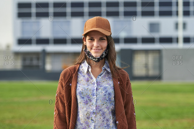 Woman wearing cap wearing face mask while standing in city