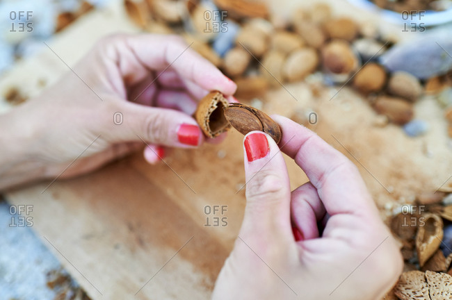 Hands of woman peeling almond