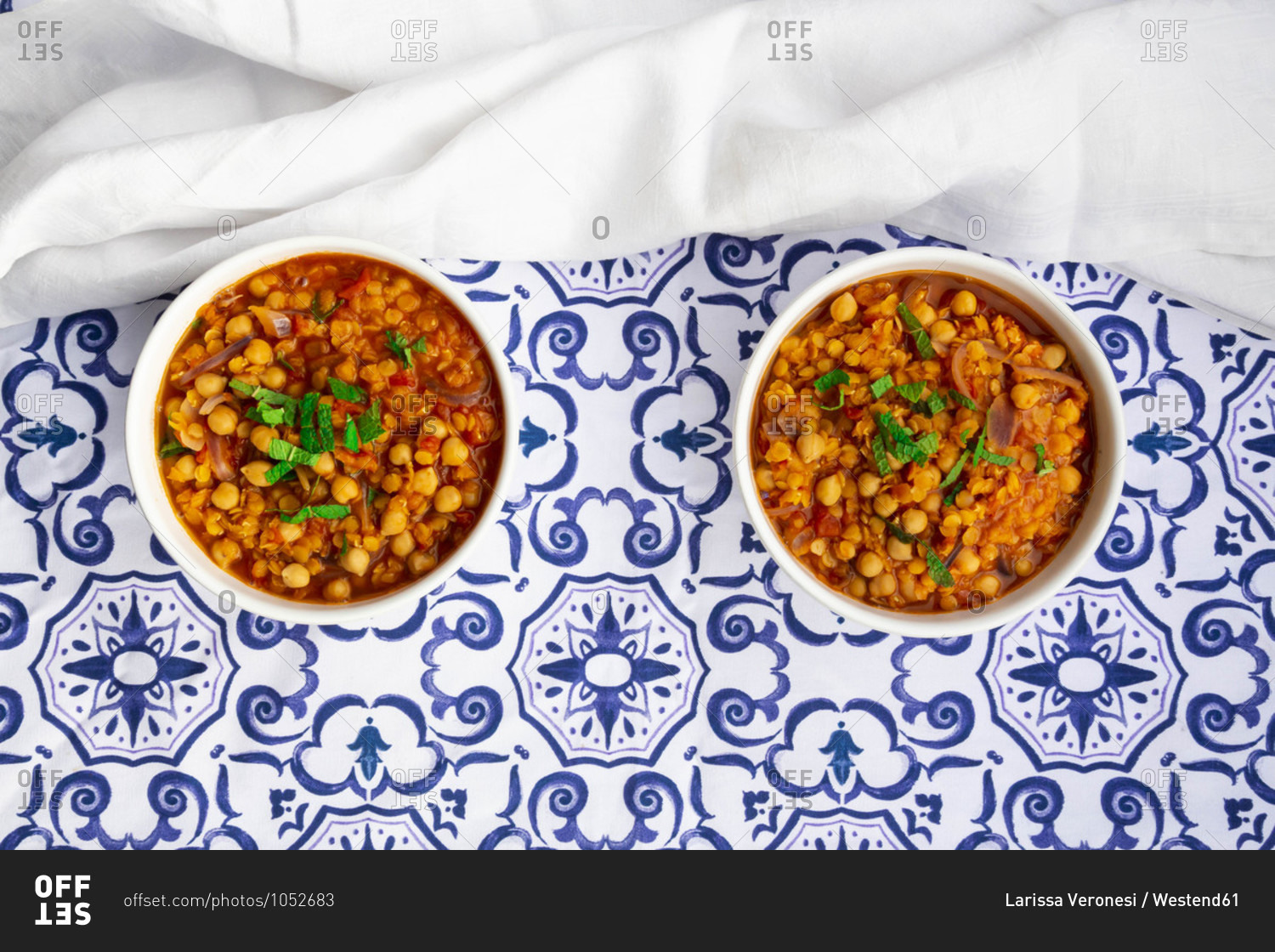 Two bowls of vegan stew with chick-peas- red lentils- tomatoes- Spanish onions and mint