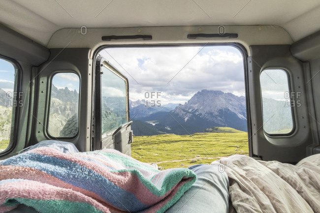 Male tourist relaxing in campervan against mountain range- Sesto Dolomites- Dolomites- Alto Adige- Italy