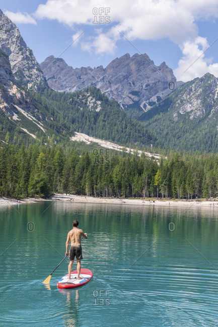 Male tourist paddleboarding on turquoise Pragser Wildsee- Dolomites- Alto Adige- Italy