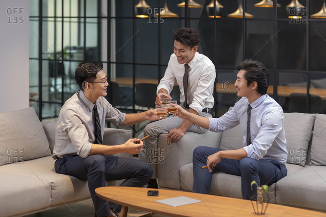 Successful Chinese businessmen drinking a toast in office