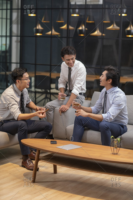 Successful Chinese businessmen drinking alcohol in office