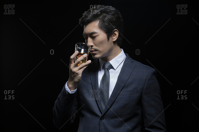 Successful Chinese businessman tasting whisky
