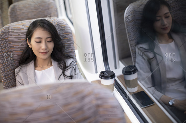 Young Chinese businesswoman resting on high-speed train