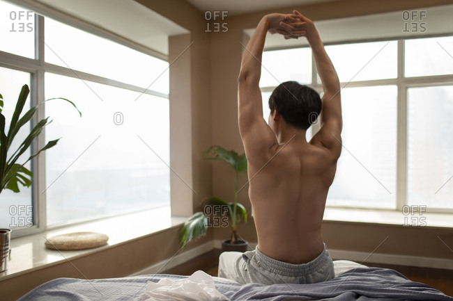 Young Chinese man waking up in the morning
