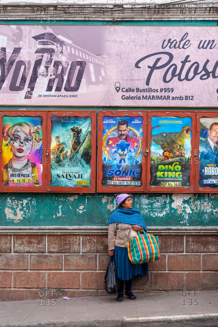 February 24, 2020: Woman on the street in front of movie posters. Potosi, Bolivia