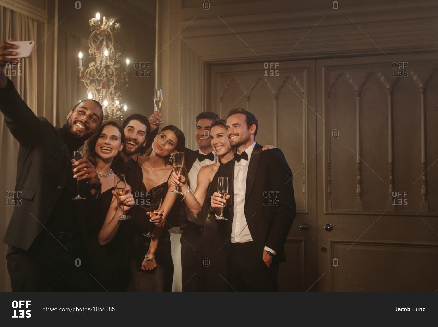 Man taking selfie with his friends at a celebrating event party. Group of multi-ethnic friends posing for a selfie together at gala night.