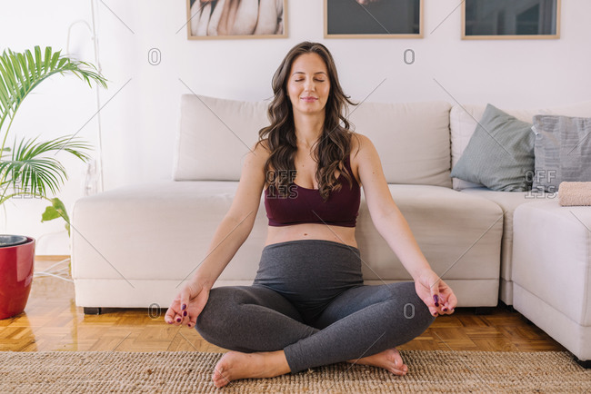 Pregnant woman meditating in her home