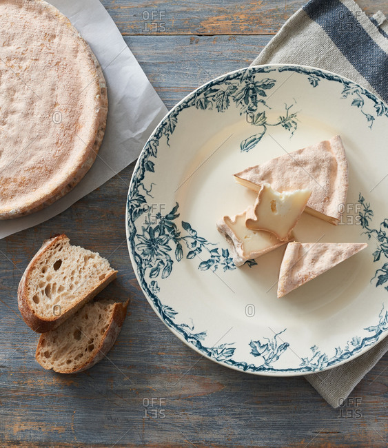 Slices of artisan cheese with a pink rind served with sourdough bread
