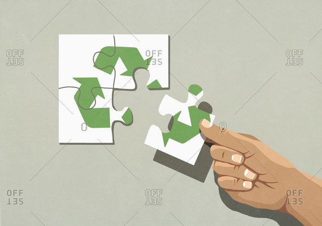 Hand finishing recycling symbol jigsaw puzzle with missing piece