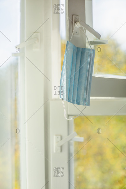 Face mask hanging from window latch
