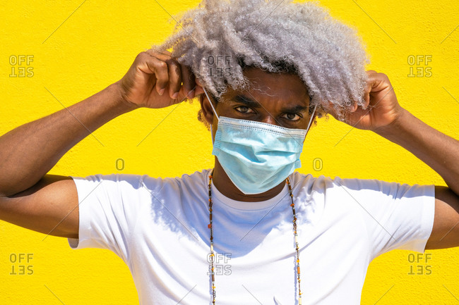 Black man with afro hair putting on mask. black man with mask. covid-19.