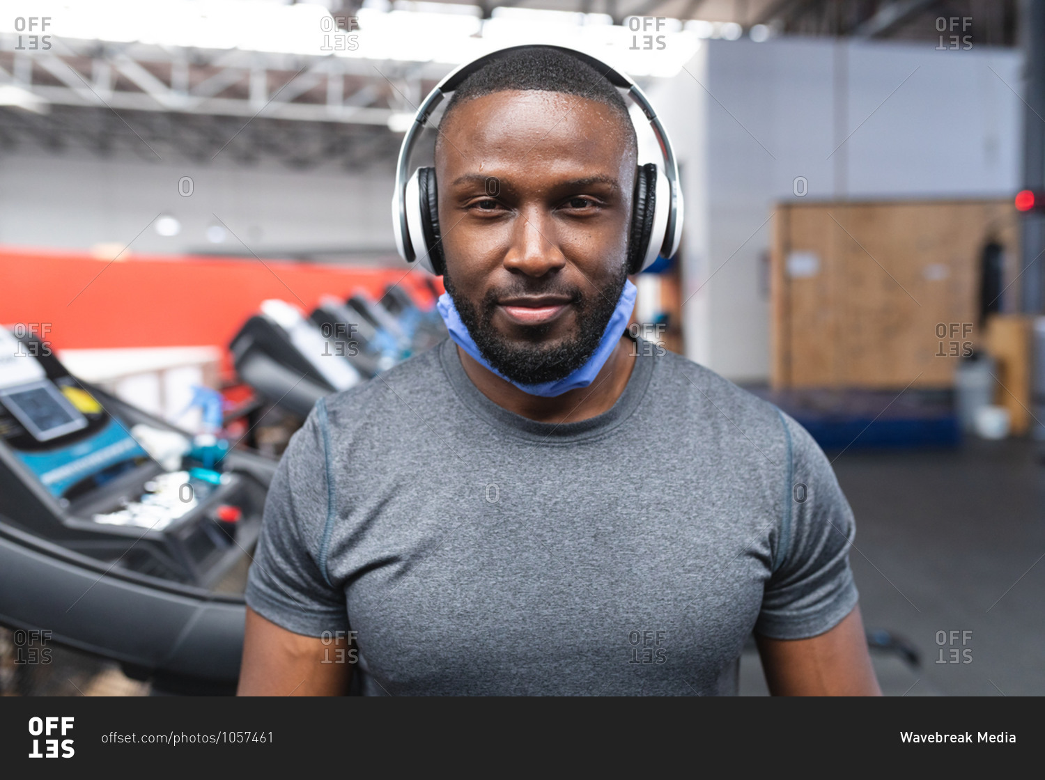 Portrait of fit African American man with face mask around his neck ...