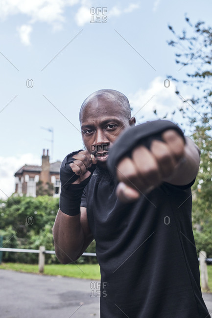Portrait of a strong man in boxing position with bandages on his hands.