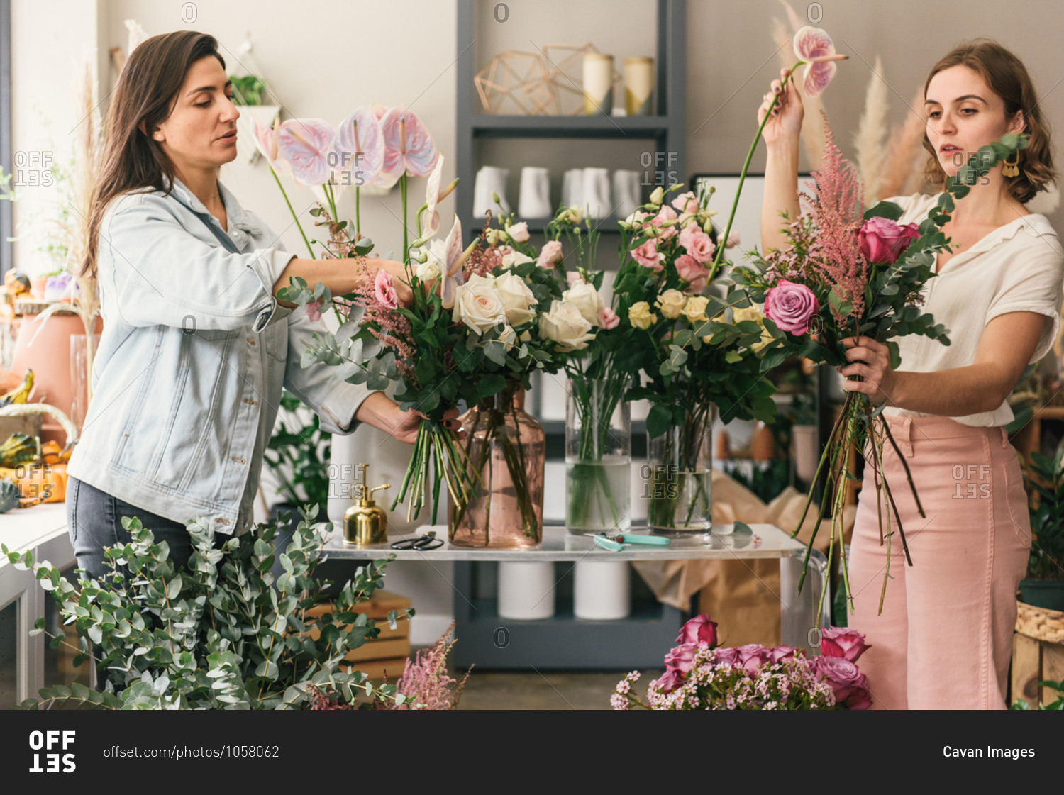 Two florists putting together bouquets in a floral workshop