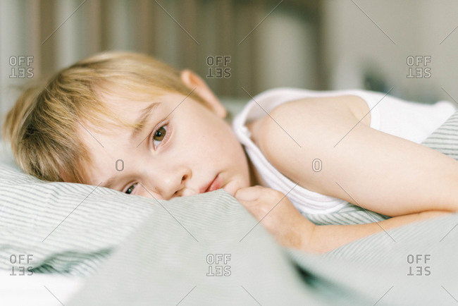 Little boy getting ready for a nap in bed