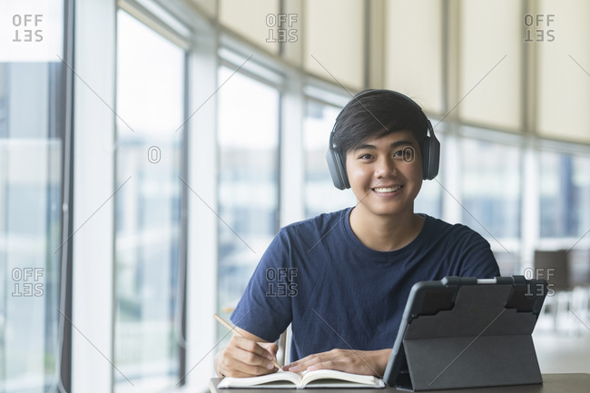 Young collage student using computer and mobile device studying
