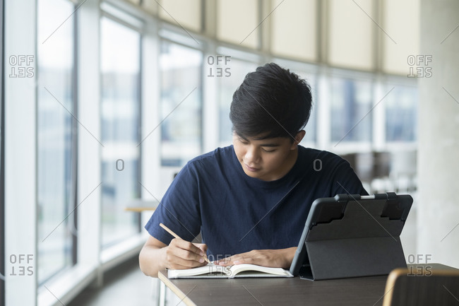 Young collage student using computer and mobile device studying