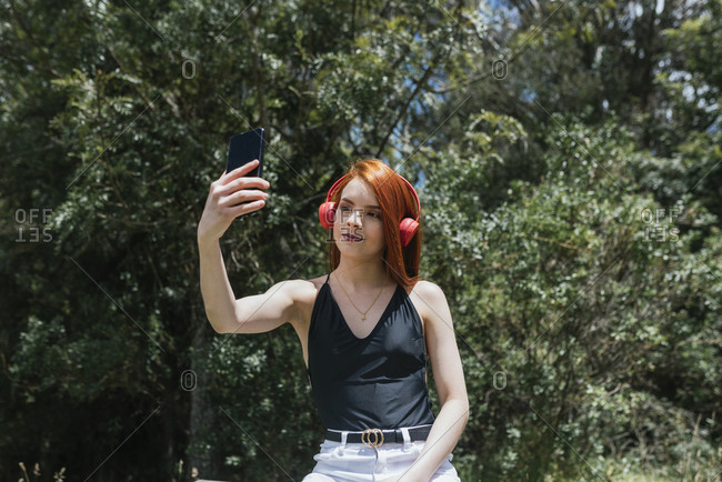Portrait of cute girl with red hair making a selfie